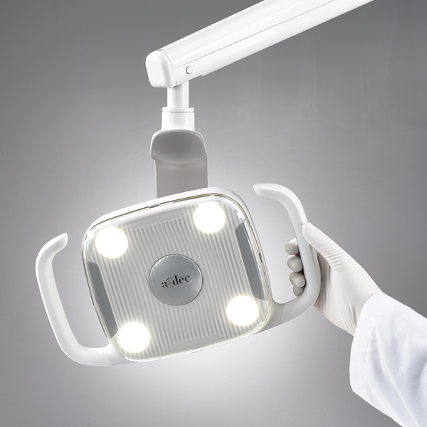 A hand positioning the A-dec 300 dental light